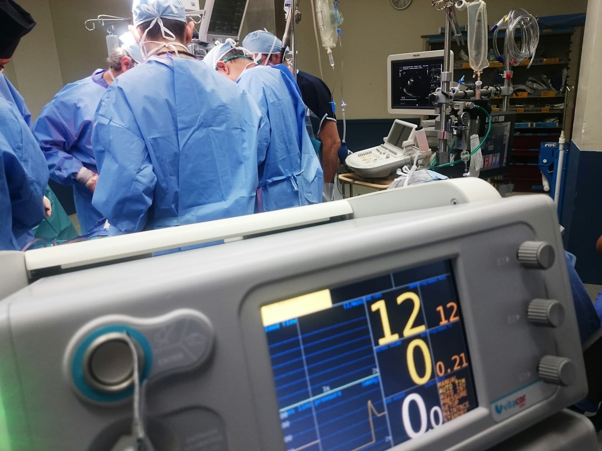 A medical team in an operating theatre, with a ventilator in front